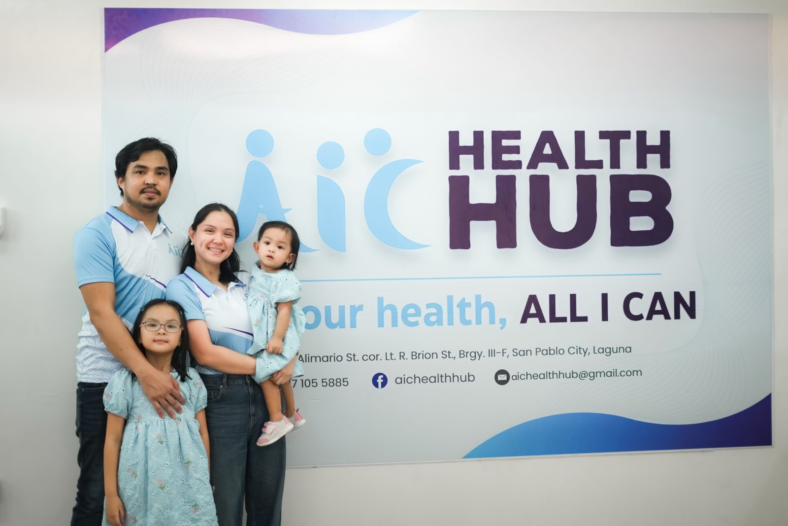 Family posing in front of a Health Hub banner